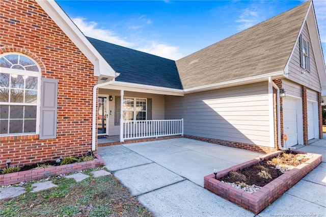 doorway to property with a porch and a garage