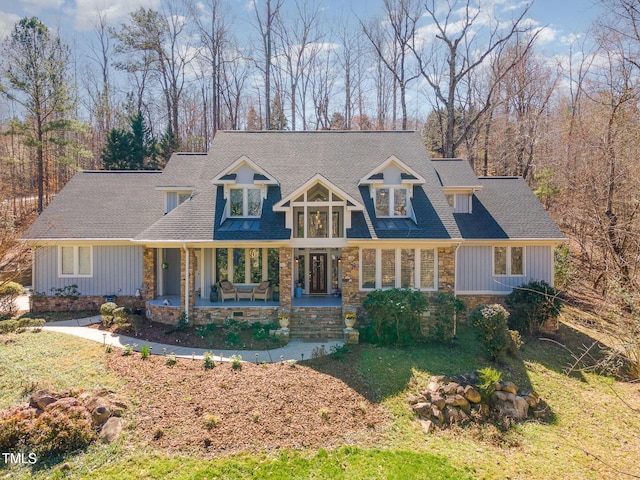 new england style home featuring a front yard and a porch