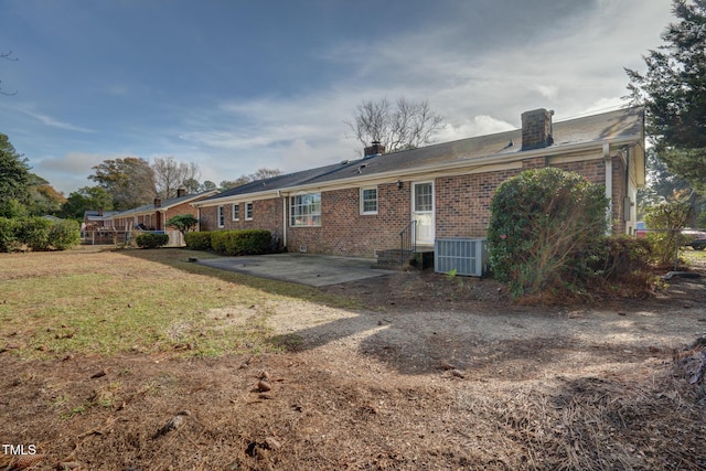 rear view of house featuring a patio, a yard, and cooling unit