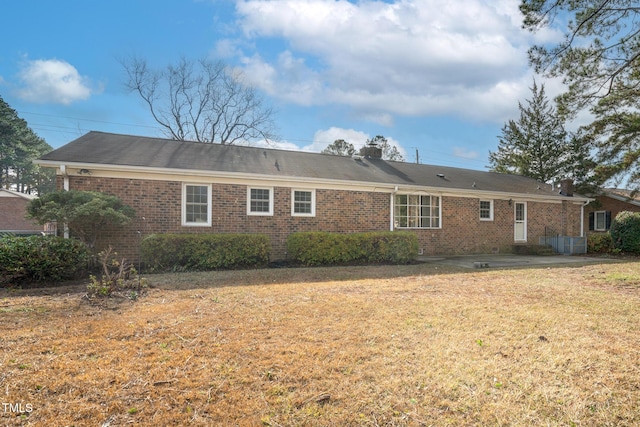 rear view of house featuring a patio and a lawn