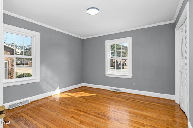 unfurnished bedroom featuring crown molding, light hardwood / wood-style floors, and a closet