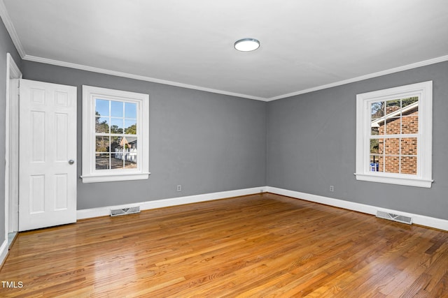 empty room featuring ornamental molding and light wood-type flooring