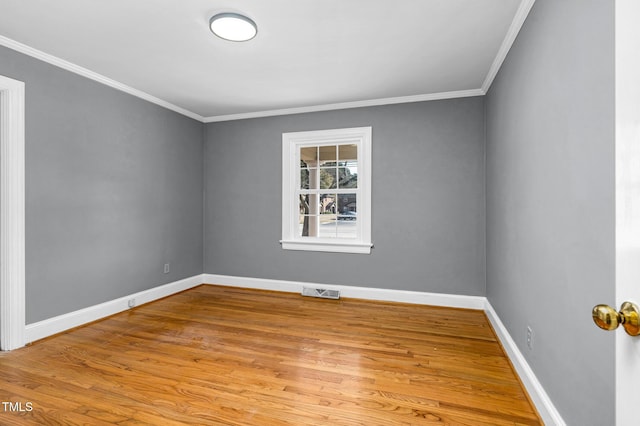 spare room featuring crown molding and light wood-type flooring