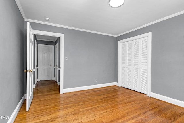 unfurnished bedroom with crown molding, light hardwood / wood-style floors, and a closet