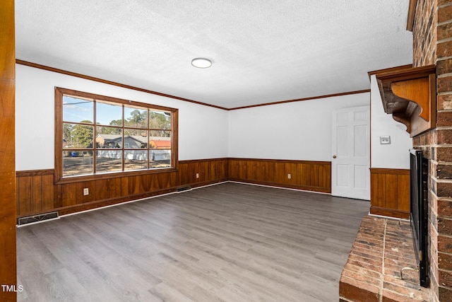 spare room featuring dark hardwood / wood-style flooring, a textured ceiling, and a fireplace