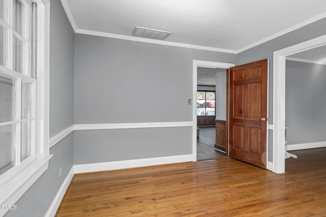 spare room with hardwood / wood-style flooring and crown molding