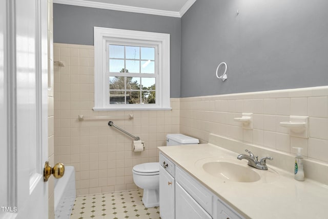 bathroom with tile walls, a bathtub, ornamental molding, vanity, and toilet