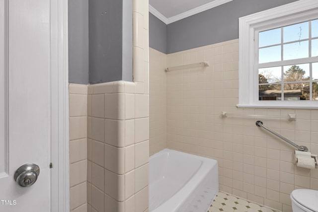 bathroom with crown molding, a tub to relax in, toilet, and tile walls