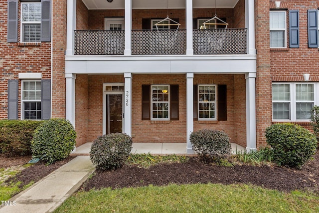 view of exterior entry featuring a balcony