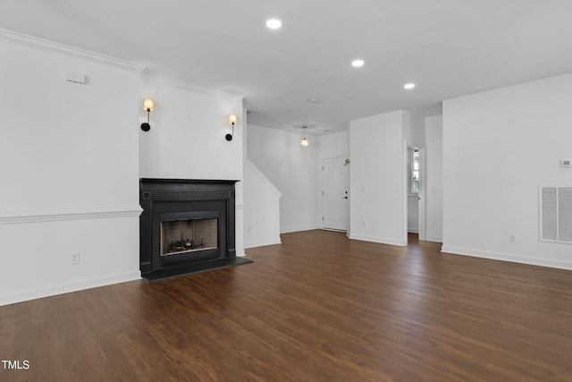 unfurnished living room featuring dark hardwood / wood-style floors and crown molding