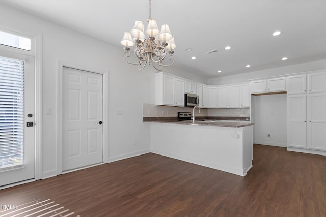 kitchen with kitchen peninsula, decorative backsplash, pendant lighting, dark hardwood / wood-style floors, and white cabinetry