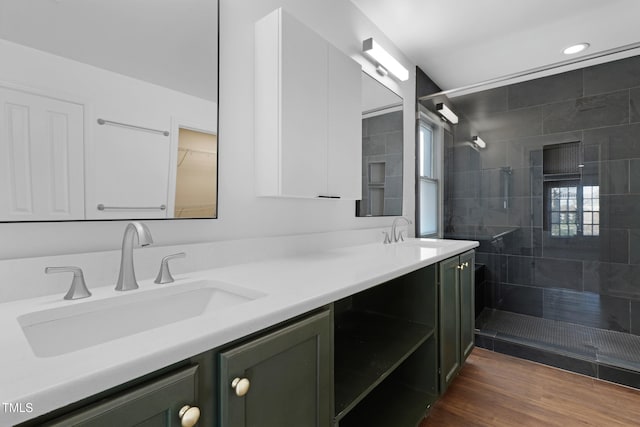 bathroom featuring tiled shower, vanity, and hardwood / wood-style flooring