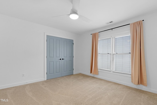 unfurnished bedroom featuring carpet flooring, ceiling fan, and a closet