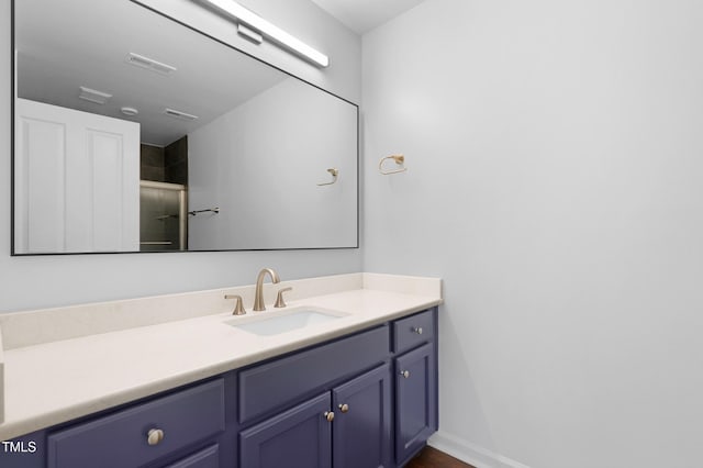 bathroom with a shower with door and vanity