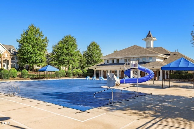 view of pool featuring a patio area and a water slide