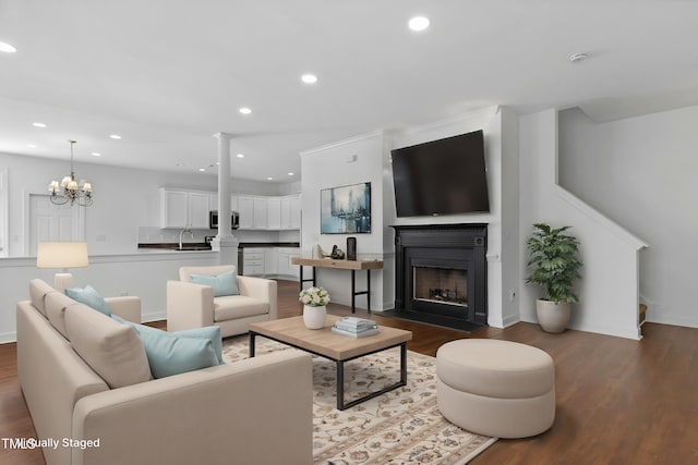 living room with sink, dark wood-type flooring, and an inviting chandelier