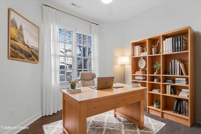 office space featuring dark hardwood / wood-style floors, ceiling fan, and a healthy amount of sunlight