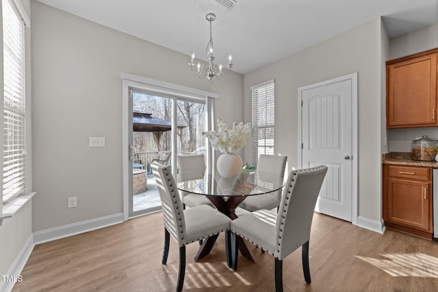 dining room with a chandelier and light wood-type flooring