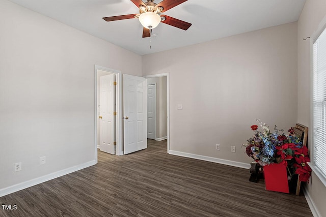 unfurnished bedroom with ceiling fan and dark wood-type flooring