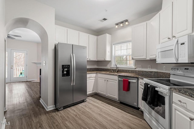 kitchen with sink, ceiling fan, appliances with stainless steel finishes, light hardwood / wood-style floors, and white cabinetry