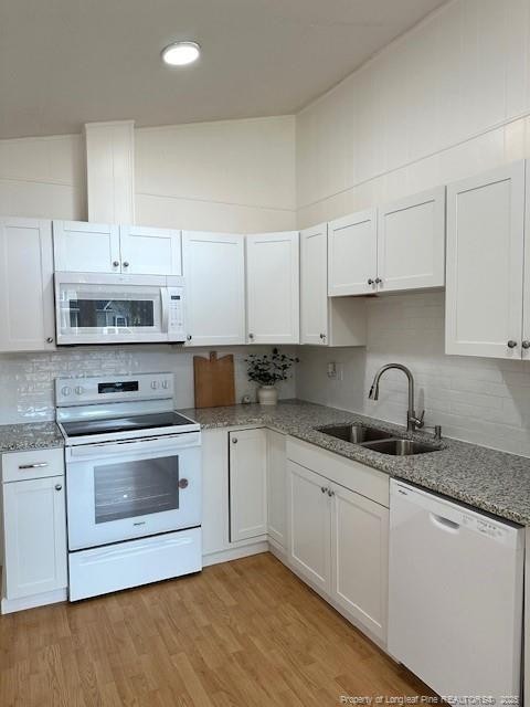 kitchen featuring white cabinets, white appliances, and sink