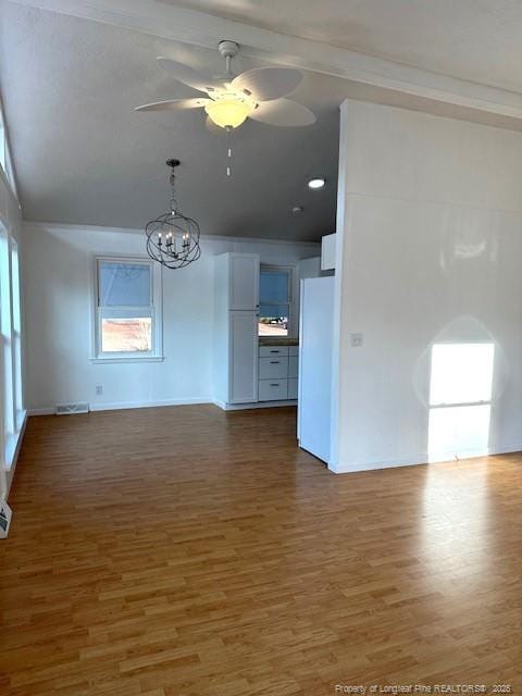 unfurnished living room with dark hardwood / wood-style flooring and ceiling fan with notable chandelier