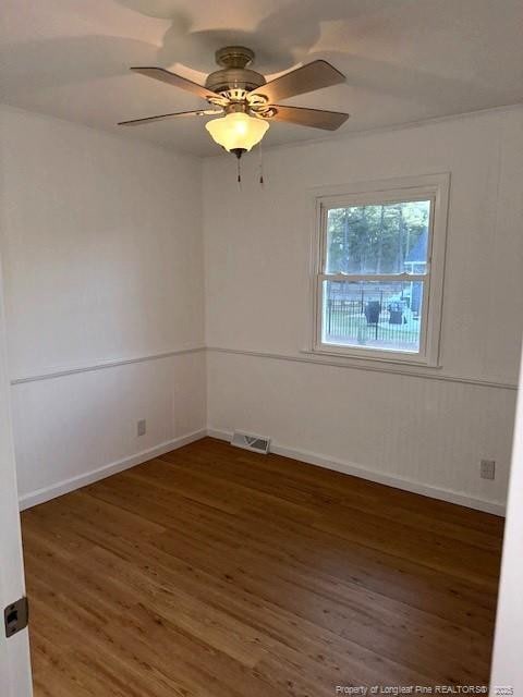 empty room with dark hardwood / wood-style floors and ceiling fan