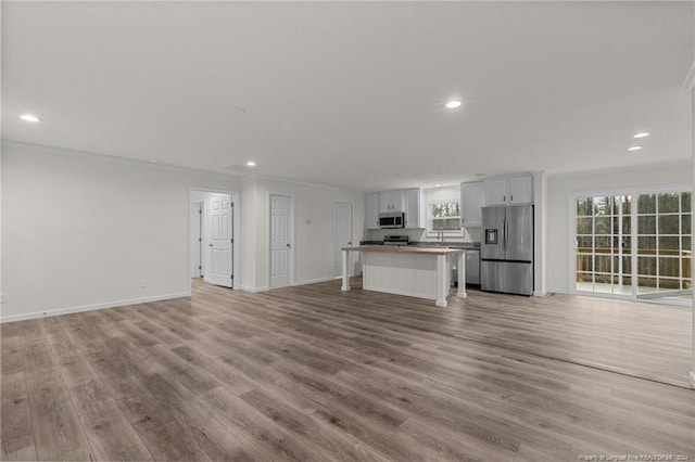 unfurnished living room featuring light hardwood / wood-style flooring and ornamental molding