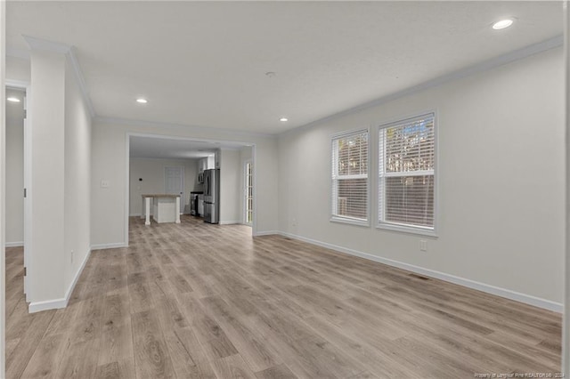 unfurnished living room featuring ornamental molding and light hardwood / wood-style flooring