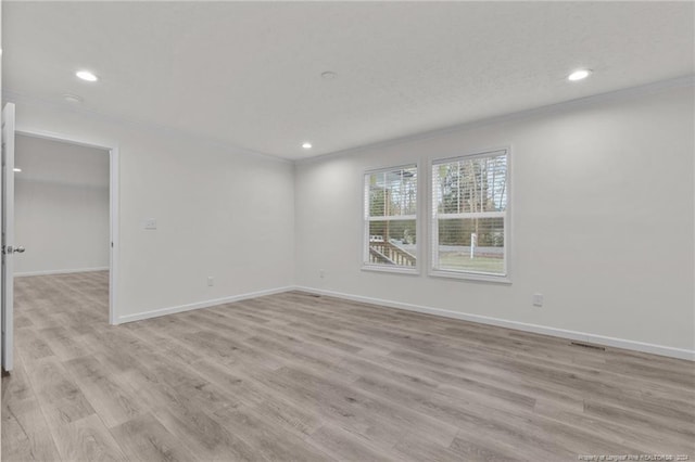 empty room with light hardwood / wood-style flooring, a textured ceiling, and ornamental molding