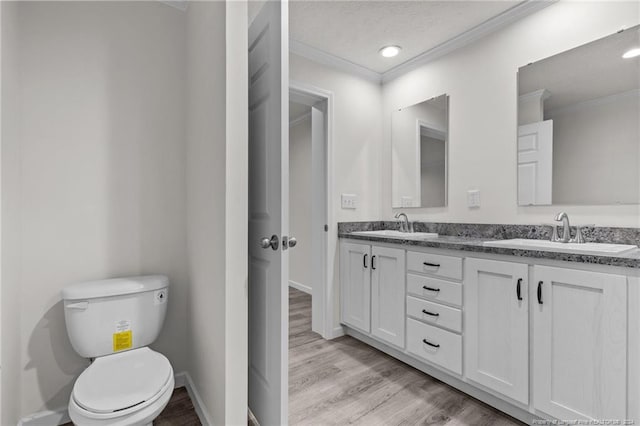 bathroom with hardwood / wood-style flooring, vanity, toilet, and ornamental molding