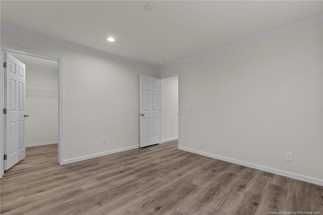 empty room featuring light hardwood / wood-style floors and ornamental molding