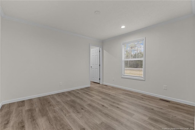 unfurnished room featuring light hardwood / wood-style floors and crown molding