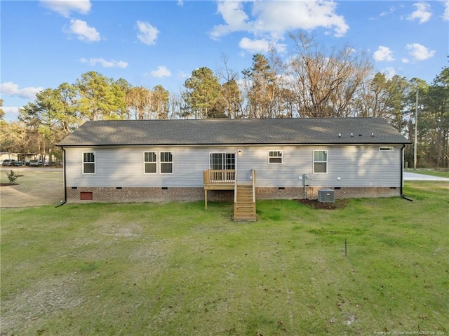 rear view of property featuring a lawn and central AC unit