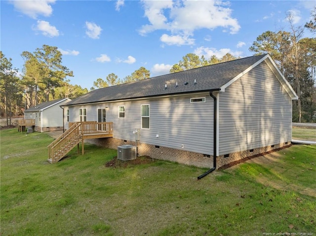 rear view of property featuring central AC, a lawn, and a wooden deck