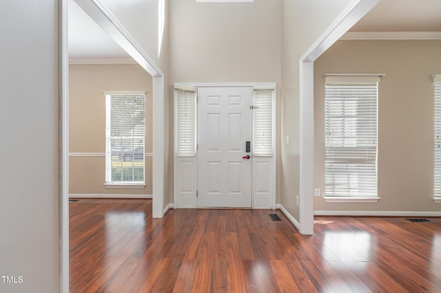 entrance foyer with hardwood / wood-style flooring, visible vents, baseboards, and crown molding