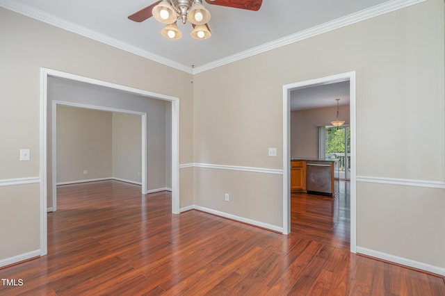 spare room featuring a ceiling fan, crown molding, baseboards, and wood finished floors