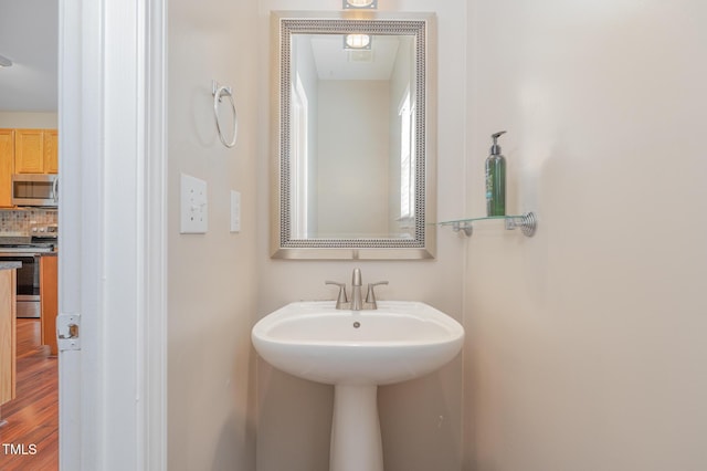 bathroom with a sink and decorative backsplash