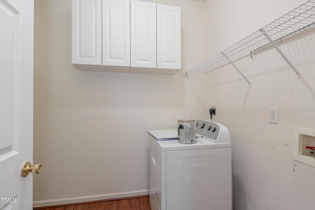 laundry area with washer / dryer, cabinet space, baseboards, and wood finished floors