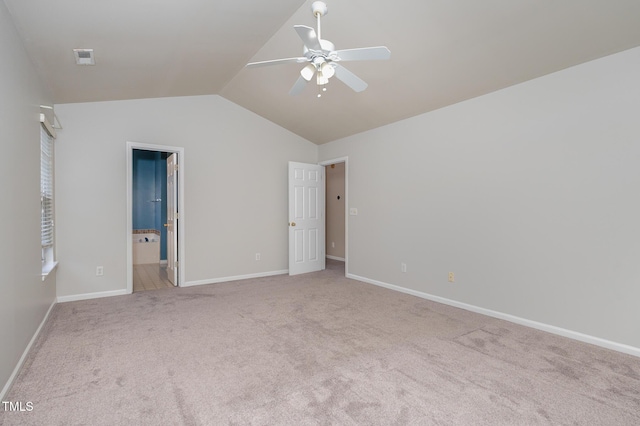 spare room with ceiling fan, vaulted ceiling, carpet flooring, and baseboards