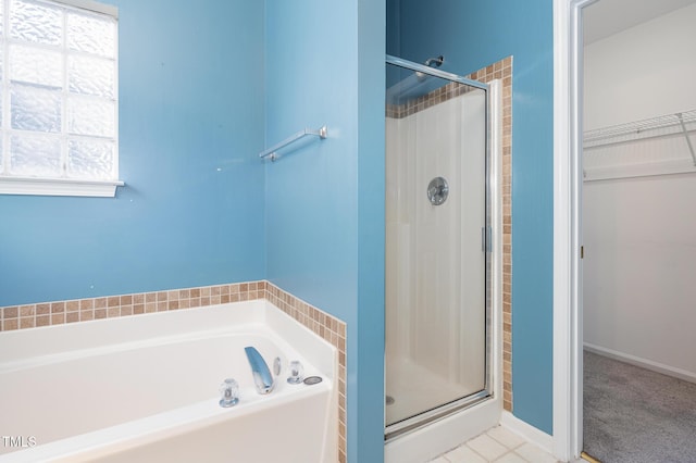 full bath featuring a wealth of natural light, a stall shower, and a spacious closet