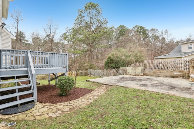 view of yard with a wooden deck, fence, and a patio