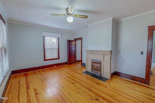 unfurnished living room featuring ceiling fan, a fireplace, light wood-type flooring, and ornamental molding