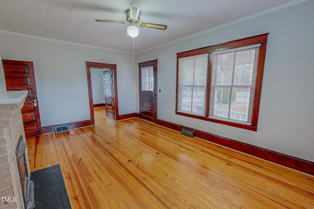 unfurnished living room with plenty of natural light, light wood-type flooring, and crown molding