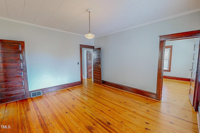 empty room with light hardwood / wood-style flooring and crown molding