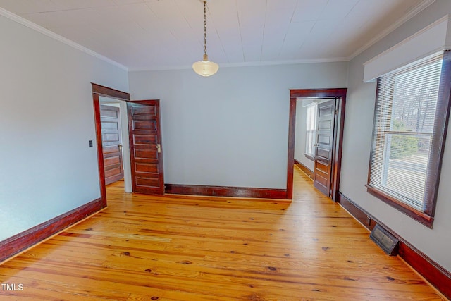 empty room featuring crown molding and light wood-type flooring