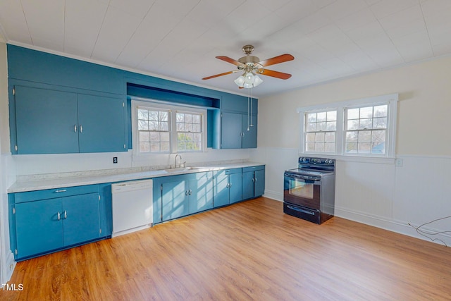 kitchen featuring white dishwasher, sink, blue cabinetry, light hardwood / wood-style floors, and black / electric stove