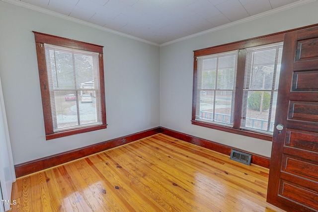 empty room featuring hardwood / wood-style flooring and crown molding