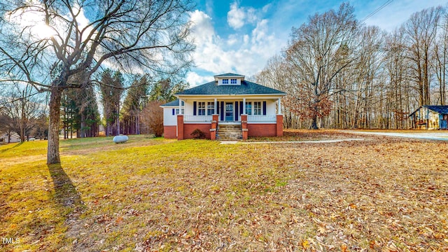 view of front of house with covered porch and a front lawn