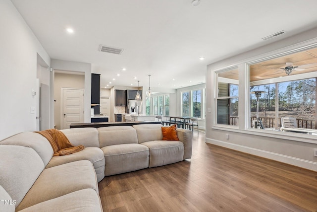 living room with ceiling fan, sink, and light hardwood / wood-style flooring